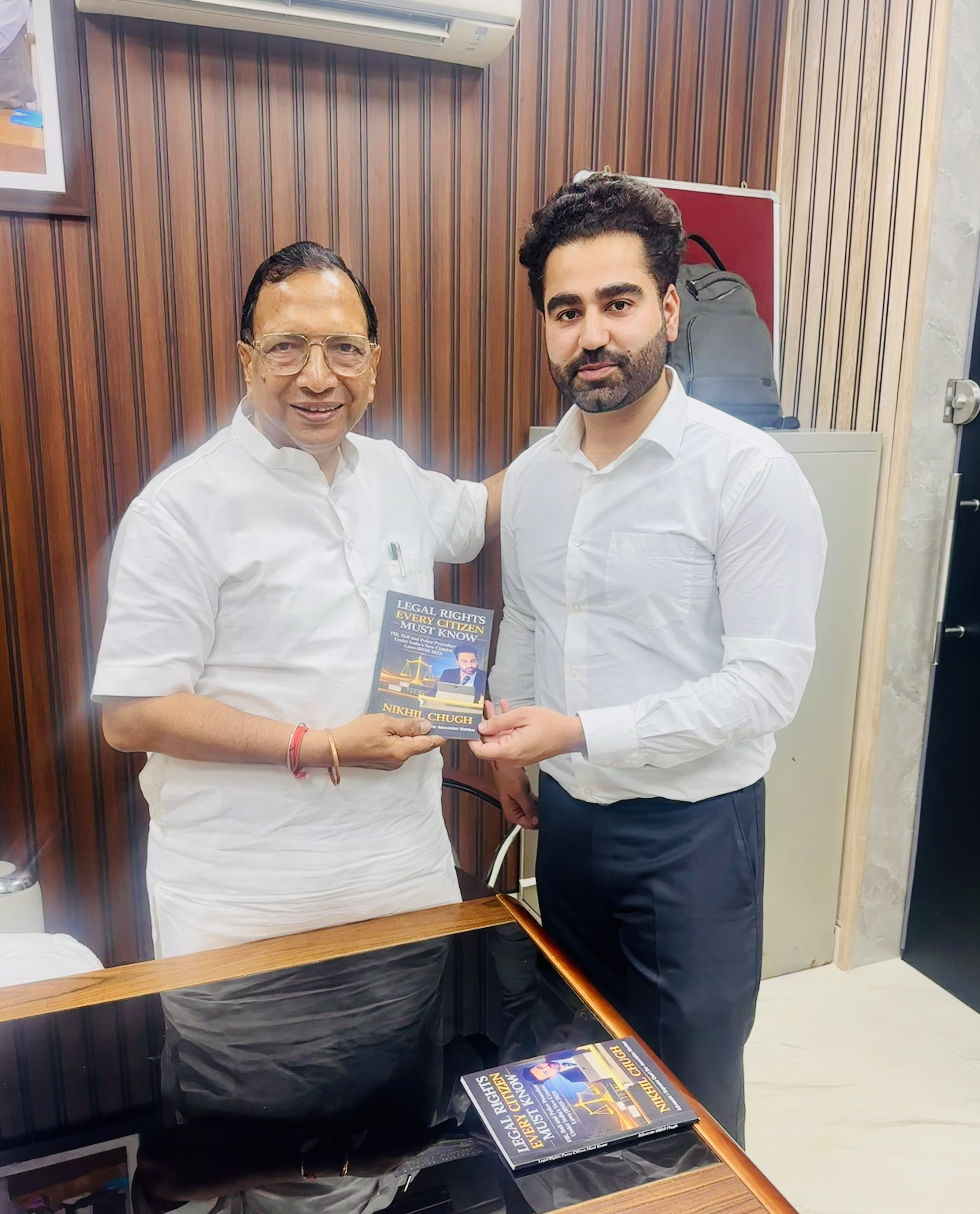 Advocate Nikhil Chugh presenting book to MLA Parmod Kumar Vij Panipat