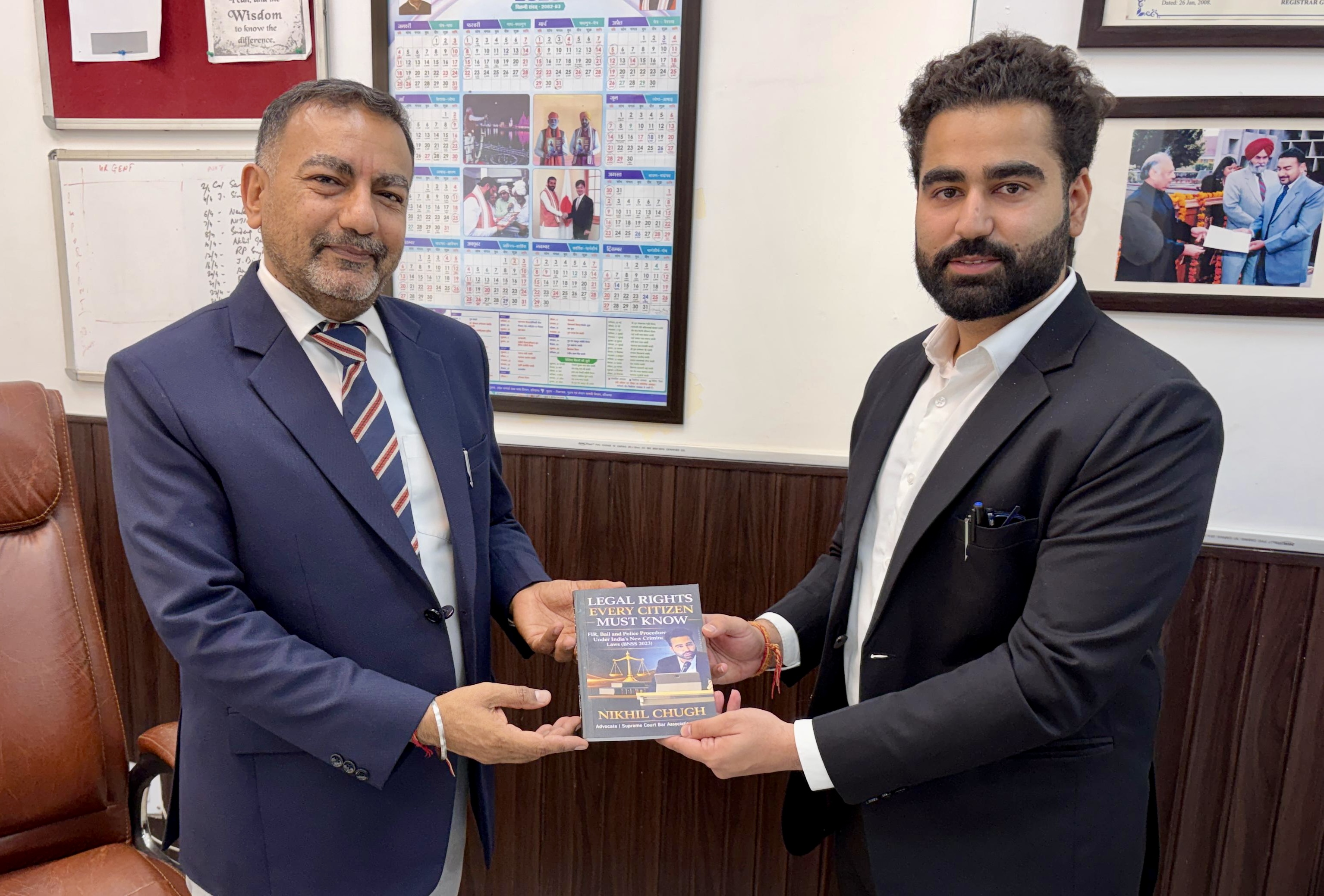 Advocate Nikhil Chugh presenting book to District Judge Sundeep Singh Panipat