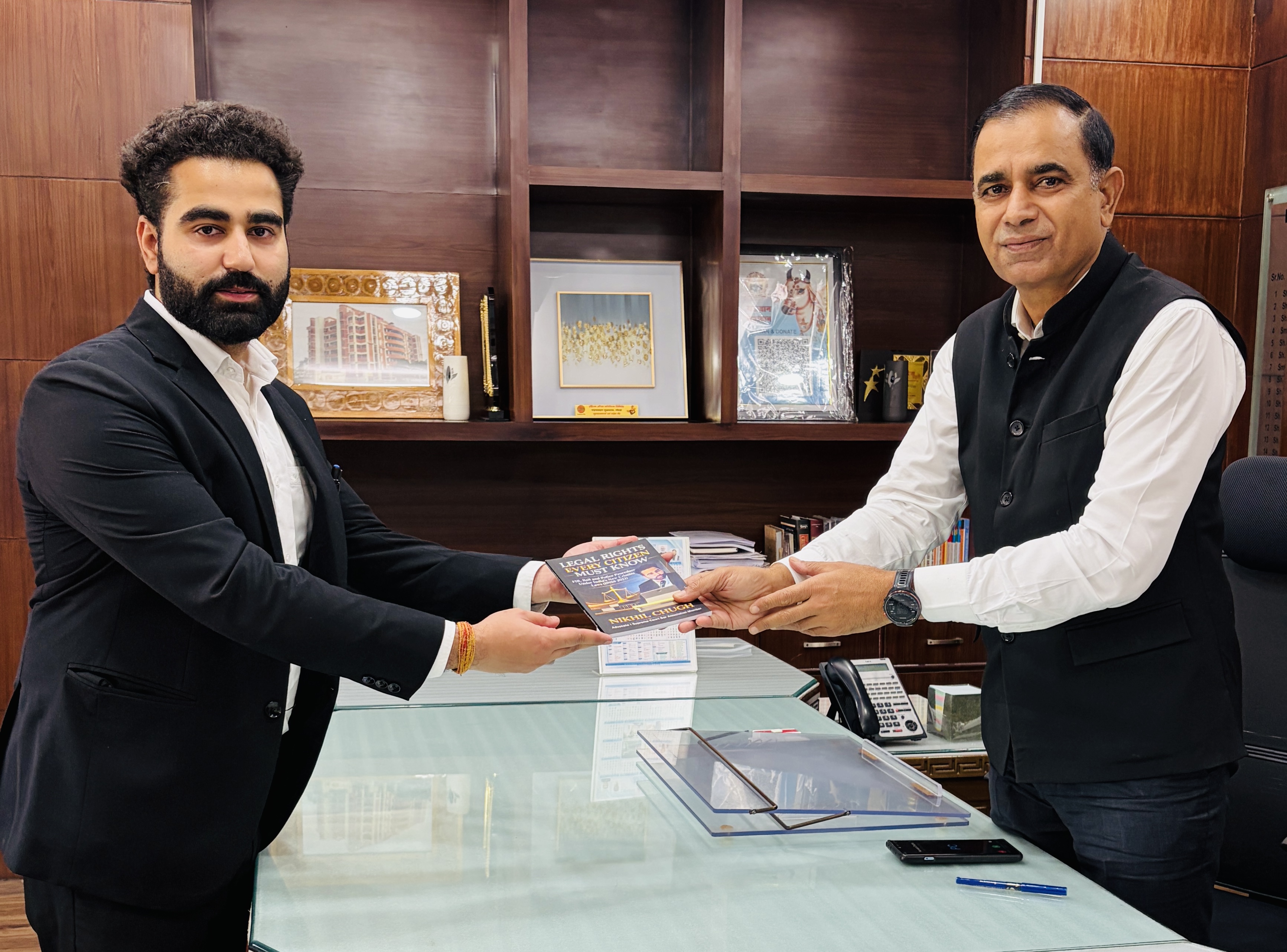 Advocate Nikhil Chugh presenting book to DC Panipat Virender Kumar Dahiya IAS